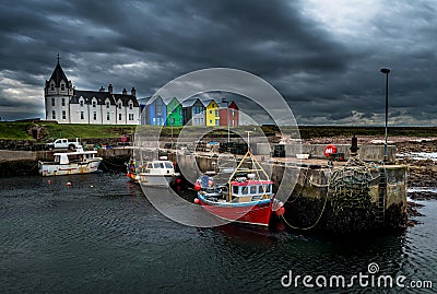 Scenic Harbor With Fishing Boats And Colorful Apartment Houses At John o`Groats In Scotland Stock Photo