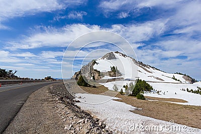 A scenic highway Rim Drive with the rocky mountain Watchman Peak background in Crater Lake National Park Stock Photo