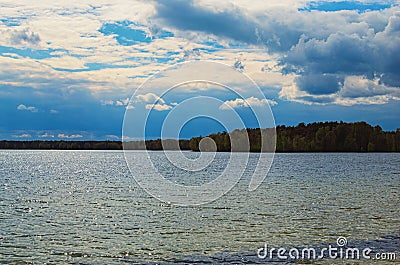 Scenic lake landscape in the forest. Rays of the sun are reflected in the blue water. Pisochne ozero Stock Photo