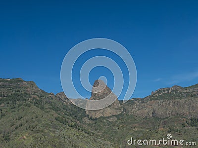 Scenic landscape with Roque de Agando rock at hiking trail through Barranco de Guarimiar Gorge. Green mountain canyon Stock Photo