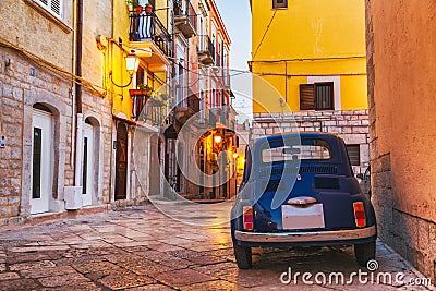 Scenic oldtown street and small retro blue car in Barletta city, Italy Stock Photo