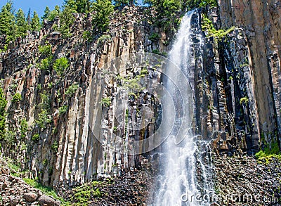 Scenic Palisade Falls flowing over steep cliff in a lush Montana forest Stock Photo