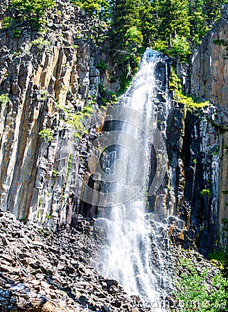 Scenic Palisade Falls flowing over steep cliff in a lush Montana forest Stock Photo