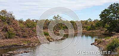 Scenic panoramic view from Sweni bird hide of the river landscape with birds and hippo in the distance Stock Photo