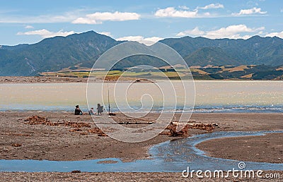 Scenic shot of people fishing at Lake Onoke with the beautiful Orongoronga Mountains in the back Editorial Stock Photo