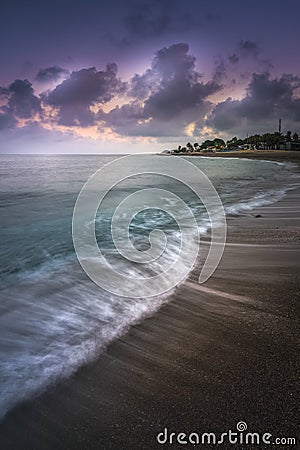 Scenic vertical shot of a seashore during twilight with the waves having a misty water effect Stock Photo