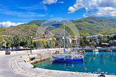 Scenic view of the bay and pier Loutraki, Greece, where small fishing schooners, yachts, boats and boats moored in the clear Stock Photo