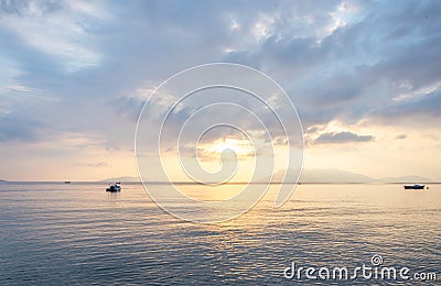 scenic view of cloudy sky, sea and fishing boat at sunset Stock Photo