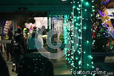 Scenic view of people entering a store decorated with colorful lights Editorial Stock Photo