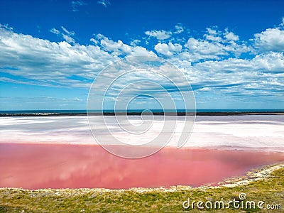 Scenic view of Pink Lake in Kalbarri, Port Gregory, Australia under a cloudy blue sky Stock Photo