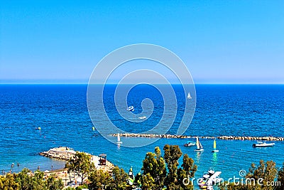 Scenic view of sandy beach with a pier with yachts and boats Stock Photo