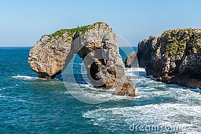 Scenic view of sea against blue sky in rocky coast Stock Photo