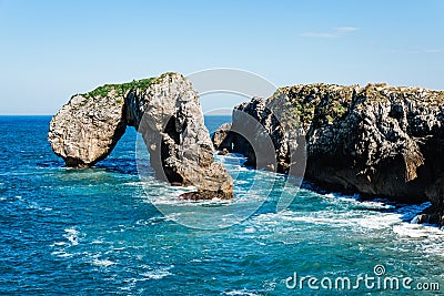 Scenic view of sea against blue sky in rocky coast Stock Photo