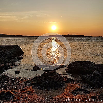 Scenic view of seashore against sunset sky Stock Photo