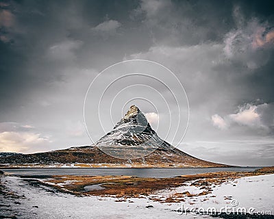 Scenic view of snowy field, river and mountain landscape in Kirkjufell, Iceland Stock Photo