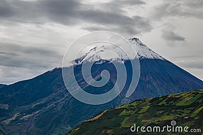 Scenic view of a snowy volcanic mountain covered with clouds Stock Photo