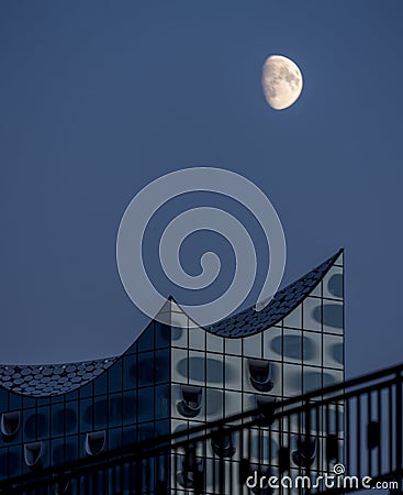 Scenic view to elbphilharmony with huge moon visible close to modern building hamburg Stock Photo