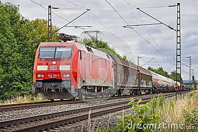 Scenic view of a train moving along the railway tracks surrounded by a lush green landscape Editorial Stock Photo