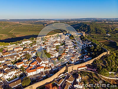 Scenic view of white houses red tiled roofs, and castle from wall of fortress. Obidos village, Portugal. Stock Photo