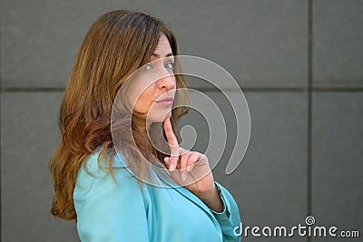 Sceptical woman looking sideways at the camera with a knowing expression Stock Photo