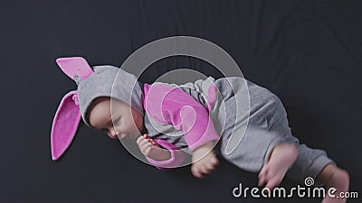 Schattige baby glimlachen en kijken in de camera dicht. kleine jongen uit het bovenaanzicht van het esster bunny costuum. stock footage Schattige baby glimlachen en kijken in de camera dicht. kleine jongen uit het bovenaanzicht van het esster bunny costuum. stock footage