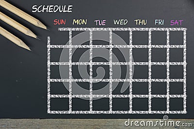 Schedule with grid time table on black chalkboard background Stock Photo