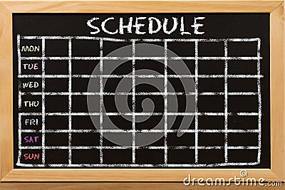 Schedule with grid time table on black chalkboard Stock Photo