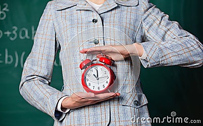 Schedule and regime. Alarm clock in female hands close up. Teachers attributes. Alarm clock in hands of teacher or Stock Photo