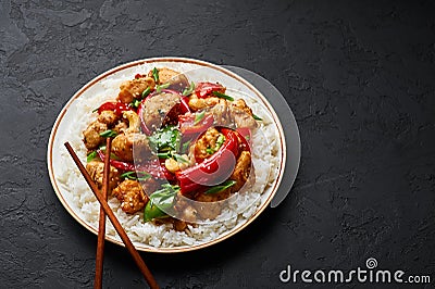 Schezwan Chicken or Dragon Chicken with basmati rice at black slate background Stock Photo