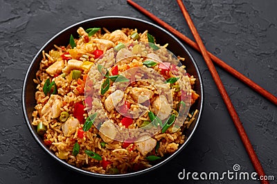 Schezwan Chicken Fried Rice in black bowl at dark slate background. indo-chinese cuisine dish Stock Photo