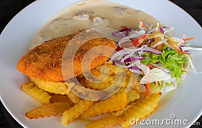 Schnitzel with potato and salad on white plate. Fried chicken cutlet top view photo on wooden table. Stock Photo