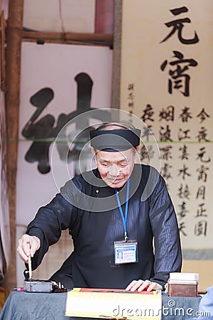 A scholar writes Chinese calligraphy characters at Temple of Literature Editorial Stock Photo