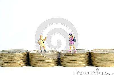 School admission budget. Children or kids, walking above golden coin money stack. Miniature tiny people toys photography. Stock Photo