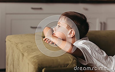 A school-age boy feeling bored lying on sofa at home, social distancing, quarantine, isolation. lock down concept. mental health Stock Photo