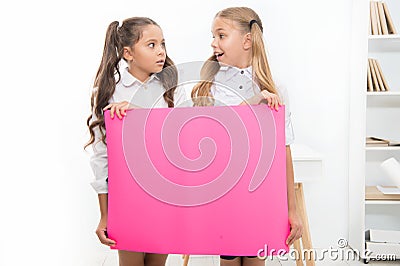 School announcement concept. Surprising news. Girls hold announcement banner. Girls kids holding paper banner for Stock Photo