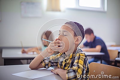 School boy yawing on class Stock Photo