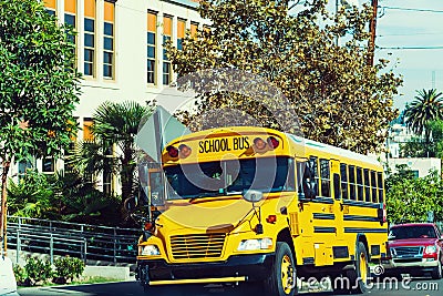 School bus parked by the school Stock Photo