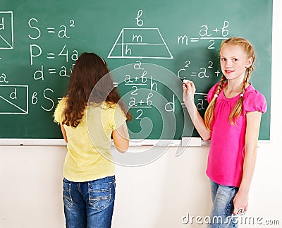 School child writting on blackboard. Stock Photo