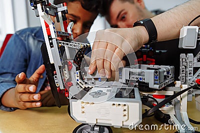 Mixed Racial group of School children controlling robotic machine with remote control together teacher. Creative kids Stock Photo