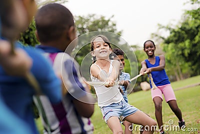 School children playing tug of war with rope Stock Photo