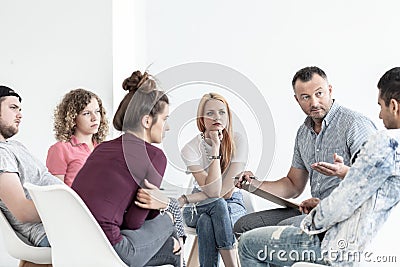 School counselor explaining anger management techniques to a group of teenagers Stock Photo