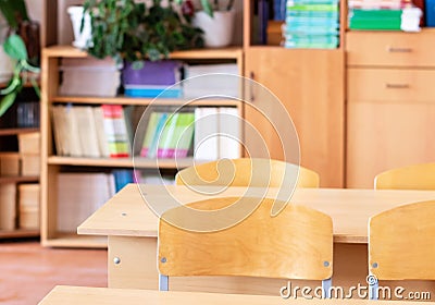 School desk against the background of school furniture in an empty classroom. Close-up, selective focus Stock Photo