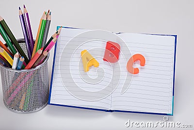 School desk concept with letters, book and pencils Stock Photo