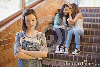 School friends bullying a sad girl in school corridor Stock Photo