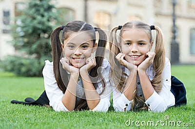 School friends formal clothes relaxing on green grass, informal education concept Stock Photo