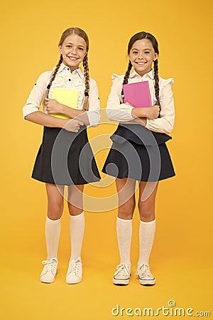 School friendship. Schoolgirls wear school uniform. Knowledge day. School day. Girl with copy books or workbooks. Study Stock Photo