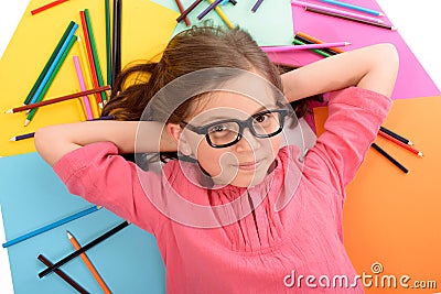 School girl lying on the floor with color pencils Stock Photo