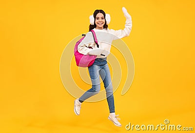 School girl teenager child student with backpack and warn hat, isolated background. Jump and run, jumping kids. Learning Stock Photo