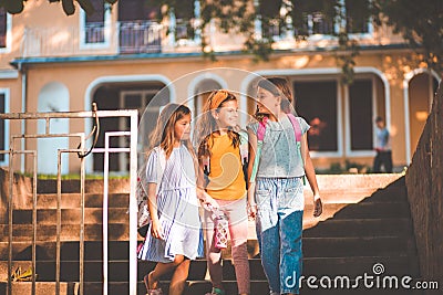 School girls going to home after school. Three little school girls walking and holding hands Stock Photo