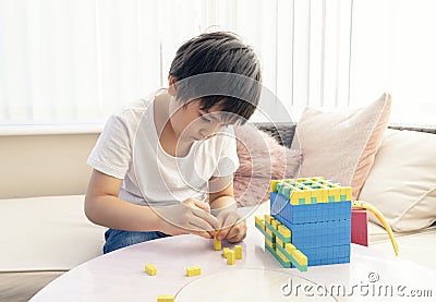 School kid using plastic block counting number,Child boy studying math by colour stack box,Montessori classroom material for Stock Photo